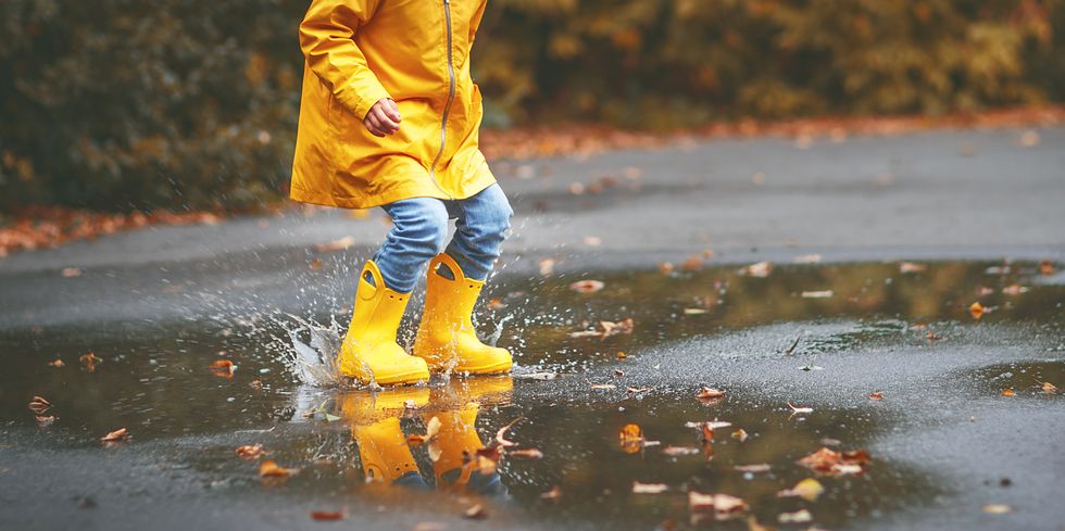 gele regenlaarzen in plas regenwater